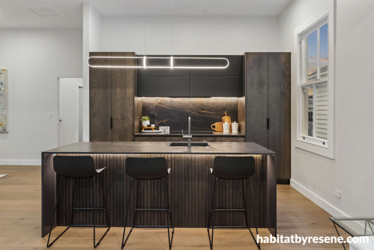 The natural grain of the oak cabinetry is shown off through the stunning dark wood stain, Resene Treehouse. Walls are painted in Resene Wan White and trims and ceiling in Resene Eighth Black White.  
