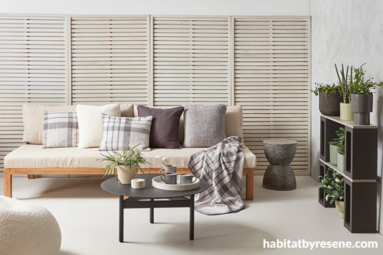 Cosy conservatory with trellis behind sofa in light colours