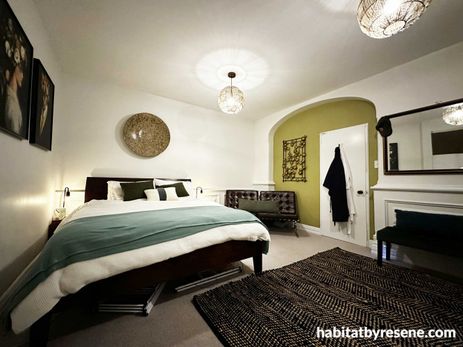 The master bedroom is bright and fresh with pops of green in décor and the vibrant arch painted in Resene Crisp Green from the Karen Walker Paints range. The walls are in Resene Black White, ceiling in Resene Eighth Black White and trims in Resene Snow Dr