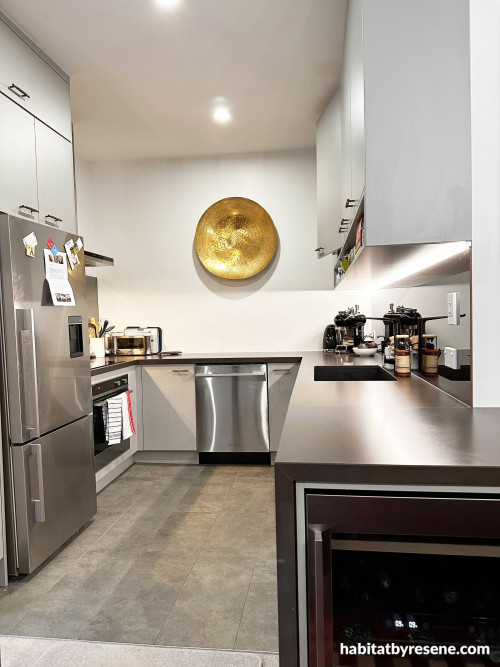 The custom splashback in the kitchen features Resene Copperhead, a brilliant fiery blend of warmth, on the reverse side of the glass.