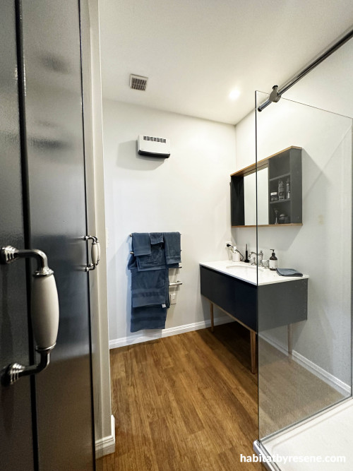 The dark blue grey of Resene Charade was chosen for the bathroom cupboards and vanity, with matching handles and walls in Resene Catskill White.