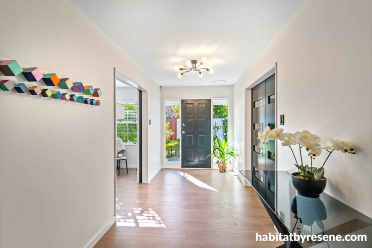 The front door and formal lounge doors, painted in Resene All Black, are the perfect contrast to this neutral hallway in Resene Merino. The ceiling and trims are in Resene Black White.