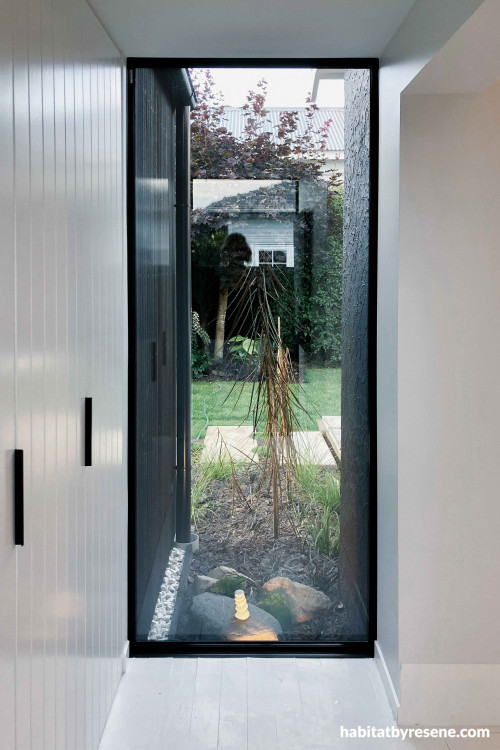 A small, glazed transition link elegantly separates the new addition from the existing bungalow