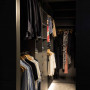 The elegant and moody walk-in wardrobe features Resene Fuscous Grey on shelving and walls, and Resene Alabaster on the ceiling. 