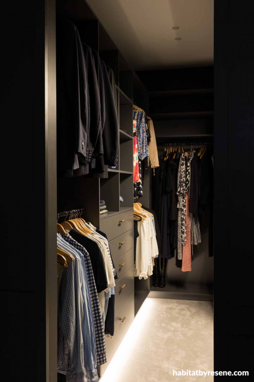 The elegant and moody walk-in wardrobe features Resene Fuscous Grey on shelving and walls, and Resene Alabaster on the ceiling. 