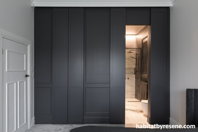 The master bedroom offers seamless sliding doors to the ensuite and walk-in wardrobe, painted in Resene Fuscous Grey, with walls in Resene Half Sea Fog and ceiling, trims and doors in Resene Alabaster. 