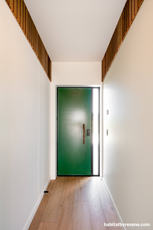 This nature inspired entryway features cedar slats at the top of the walls