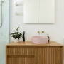 The green tiles and blushing pink sink mimic the colourful theme throughout the home, working well with the walls painted in Resene Quarter Merino.