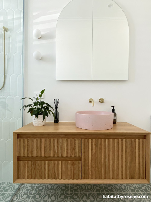 The green tiles and blushing pink sink mimic the colourful theme throughout the home, working well with the walls painted in Resene Quarter Merino.