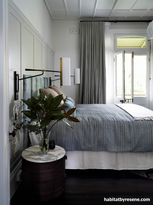 The delightful master bedroom features a panelled headboard painted in Resene Half Ash, with Resene Quarter Ecru White on walls and Resene Half Black White on trims and detailing. 