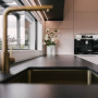 Dusty amber toned pink brings a sense of serenity to this kitchen