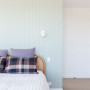 Bedroom with panelled wall painted in soft light green tone