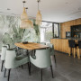 Open-plan dining room and kitchen featuring nature-inspired wallpaper