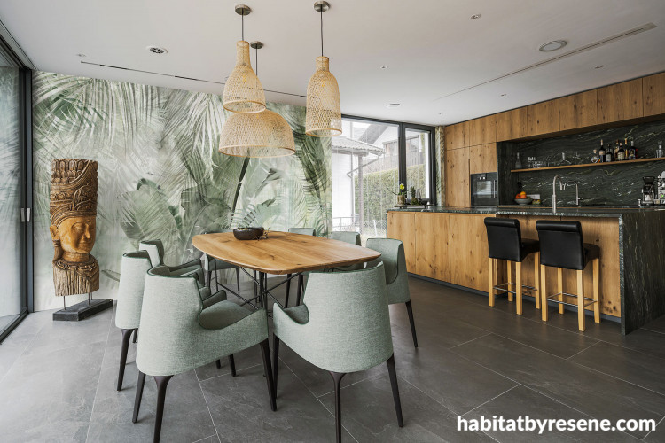 Open-plan dining room and kitchen featuring nature-inspired wallpaper