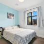 Bedroom featuring white walls and ceiling and a soft blue feature wall