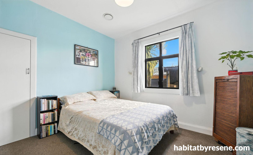 Bedroom featuring white walls and ceiling and a soft blue feature wall