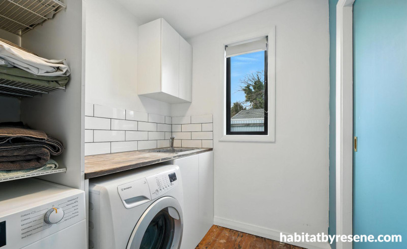 White laundry with a light blue door and back wall