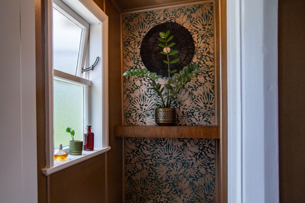 Window with patterned floral wallpaper on the adjacent wall.