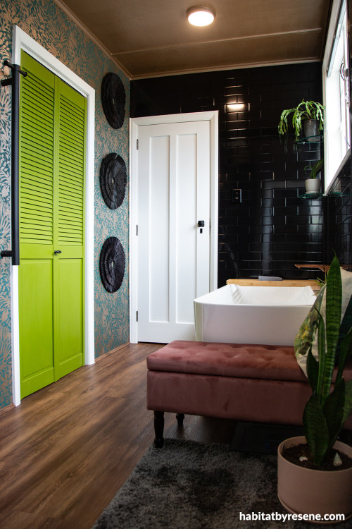 Bathroom featuring moody black tiles, Resene wallpaper and vivid green doors