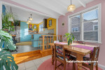 Dining room featuring soft pink walls and kitchen featuring bright yellow walls and soft blue cabinetry