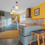 Kitchen featuring bright yellow walls and soft blue cabinets