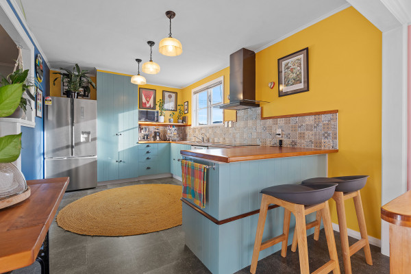 Kitchen with bright yellow walls and soft blue cabinets.
