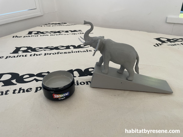 Elephant on a doorstop with a paint pot