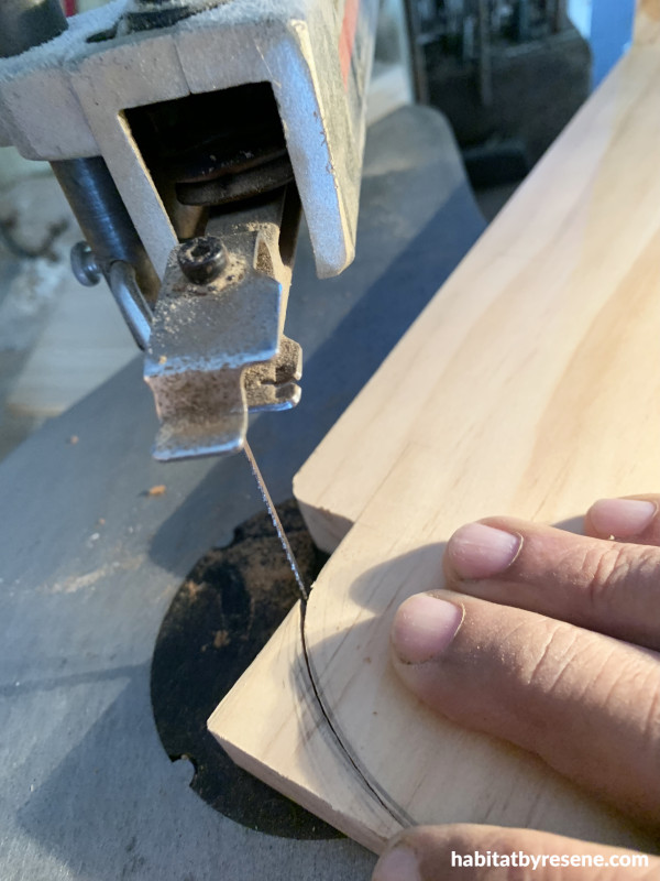 A saw cutting a curve into a piece of wood