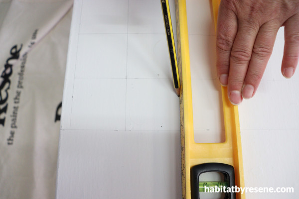 A person measuring a white surface