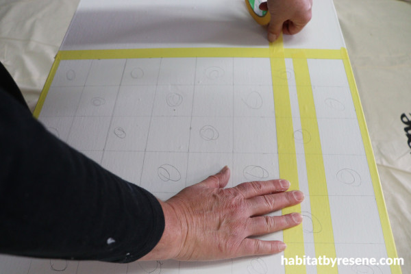 A person's hand taping a white surface