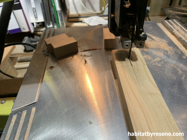 A saw cutting a piece of wood into a thin strip