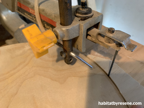 A saw cutting a curve into a piece of wood