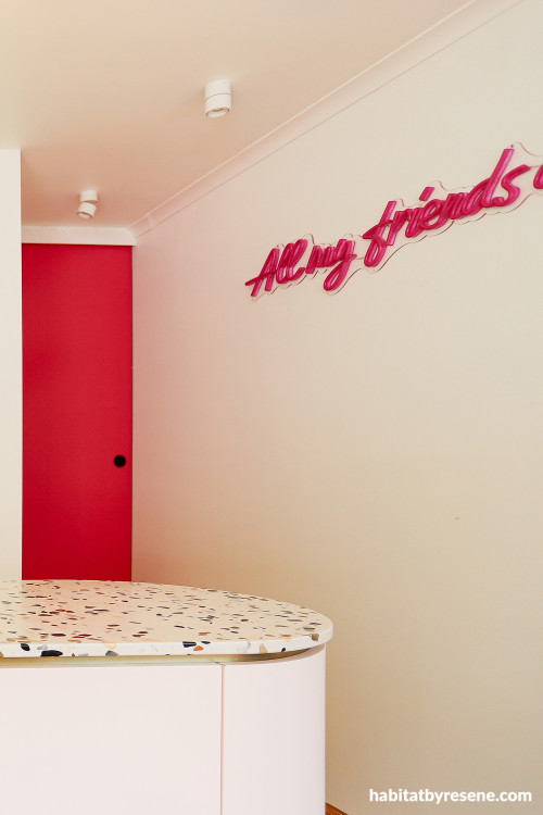 Ktichen featuring bold pink door and white walls