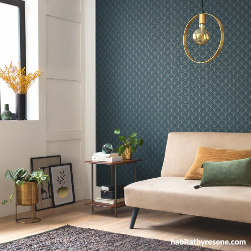 Living area featuring statement teal blue wallpaper with subtle geometric pattern