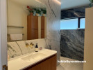 Bathroom with marble-look panels and painted in Resene Wheatfield