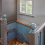 Natual wood staircase with walls painted half in grey and half in blue