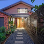 House exterior featuring weatherboards in Resene Wombat, fence in Triple Friar Greystone