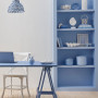 Dining area featuring neutral white wall and blue bookshelf