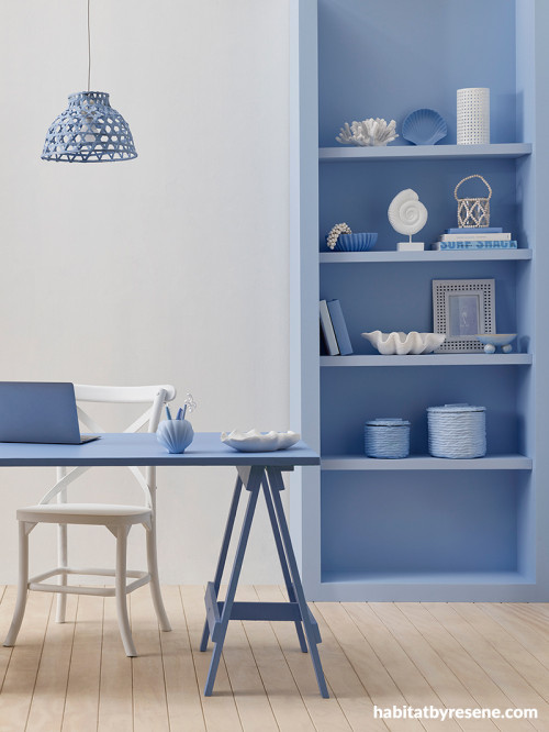 Dining area featuring neutral white wall and blue bookshelf
