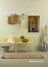 A yellow entry with a bench seat and wall hooks