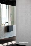 Bathroom featuring tiled vanity and textured wallpaper