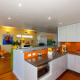kitchen, dining room, orange splashback, bright kitchen, yellow feature wall, renovated villa