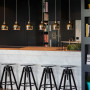 apartment, kitchen, benchtop, hanging lights, gold lighting, dark grey paint, barstools 