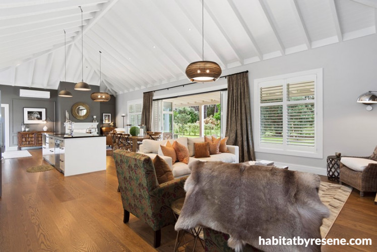 white lounge, white living room, open plan living, high ceiling, exposed rafters, timber flooring