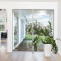 entranceway, wood front door, indoor plant, white living area, white house