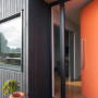 house exterior, black house, orange front door, black exterior, orange and black, black cladding