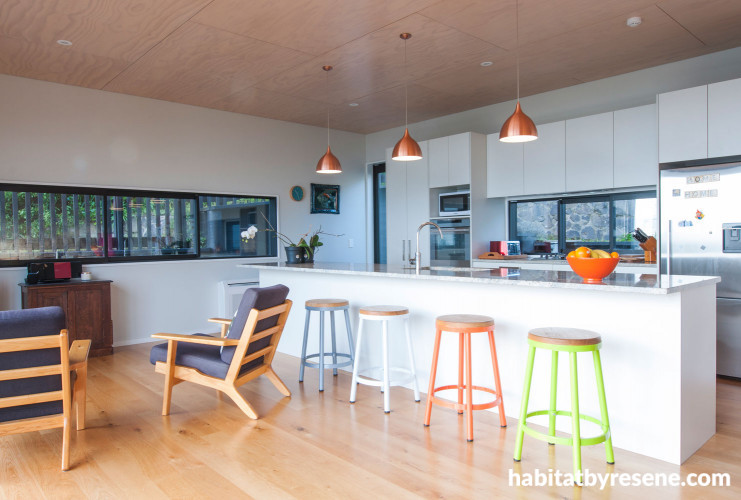 kitchen, white kitchen, wood ceiling, coloured bar stools, timber floors, white living room