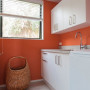 laundry, orange laundry, white cabinetry, white and orange, orange paint, orange interior