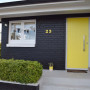 house exterior, black house, yellow front door, bright yellow door, painted black bricks