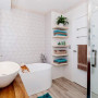 white bathroom, freestanding bath, geometric tiles, open shelving 